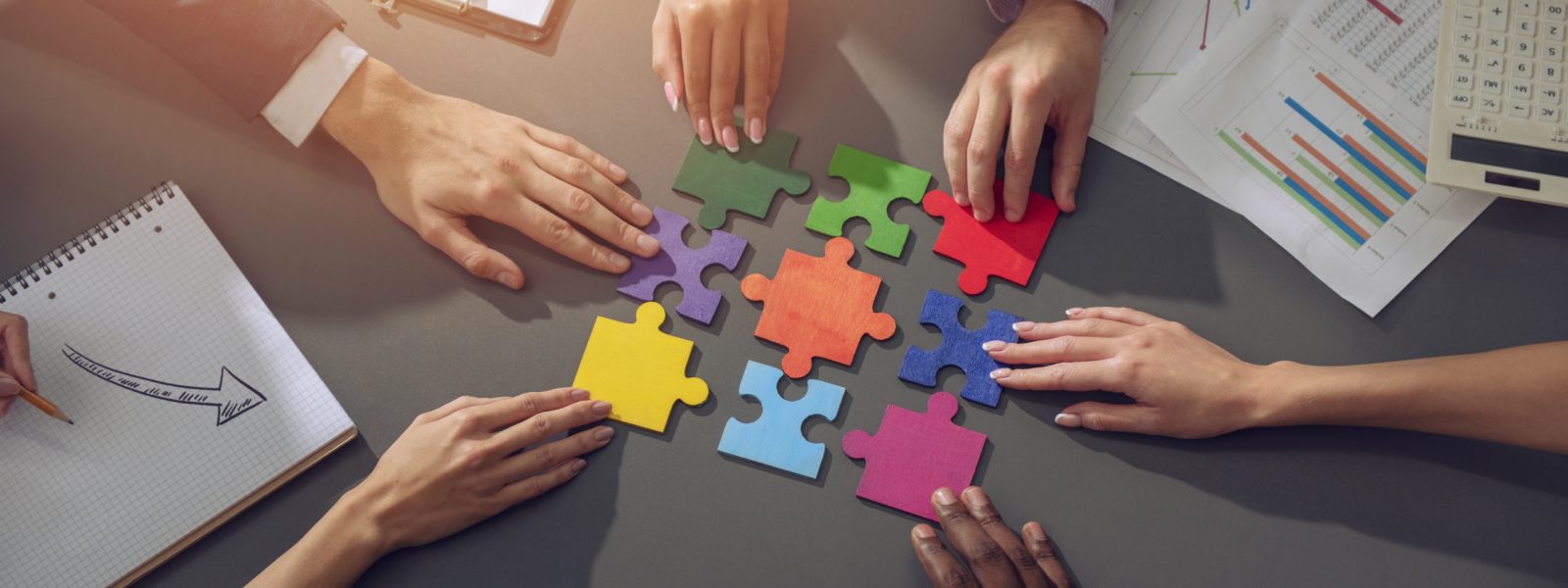 Businessmen working together to build a puzzle. Concept of teamwork, partnership, integration and startup.